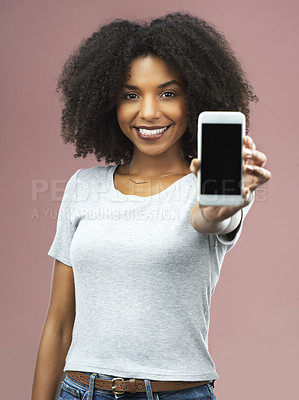 Buy stock photo Studio shot of an attractive young woman holding a smartphone with a blank screen against a pink background