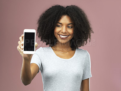 Buy stock photo Studio shot of an attractive young woman holding a smartphone with a blank screen against a pink background