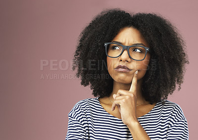 Buy stock photo Shot of a beautiful young woman looking thoughtful against a pink background