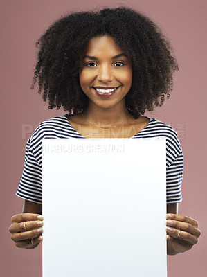 Buy stock photo Studio shot of an attractive young woman holding a blank placard against a pink background