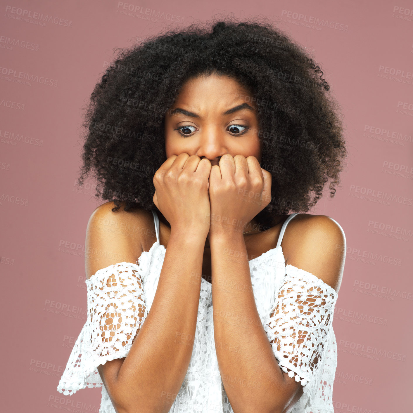 Buy stock photo Shot of a beautiful young woman looking scared against a pink background