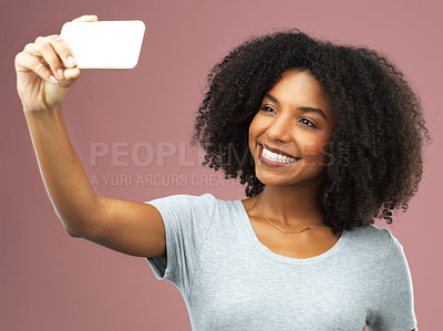 Buy stock photo Studio shot of an attractive young woman taking a selfie against a pink background