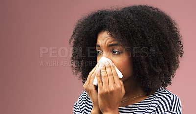 Buy stock photo Cropped shot of a young woman blowing her nose into a tissue