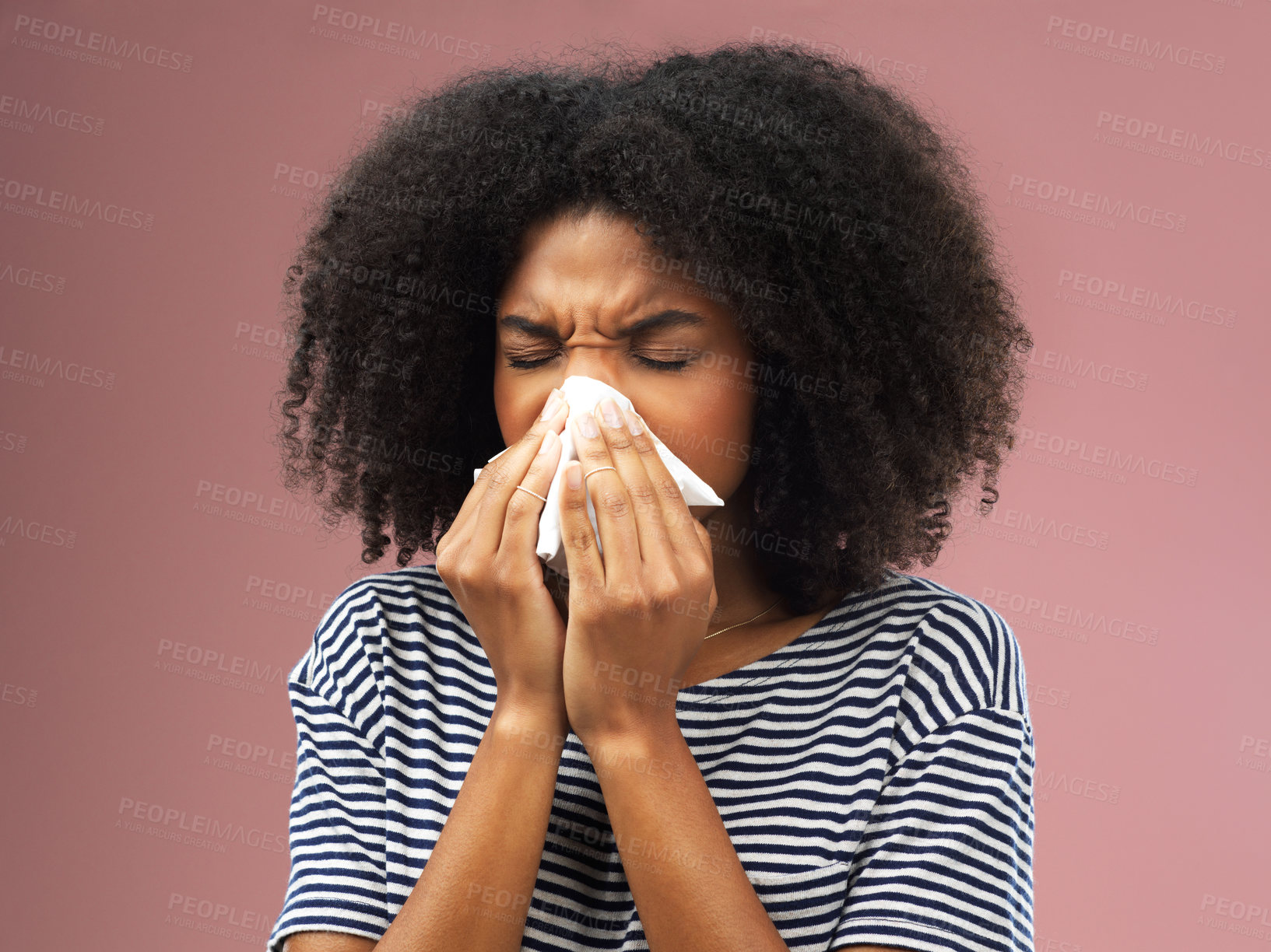Buy stock photo Cropped shot of a young woman blowing her nose into a tissue