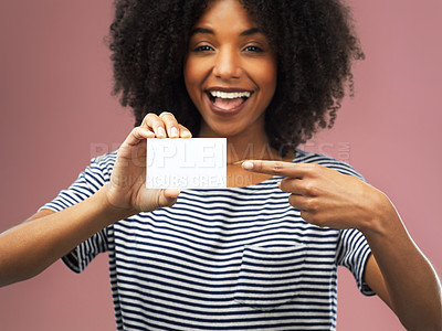 Buy stock photo Shot of a young woman holding up a blank card against a pink background