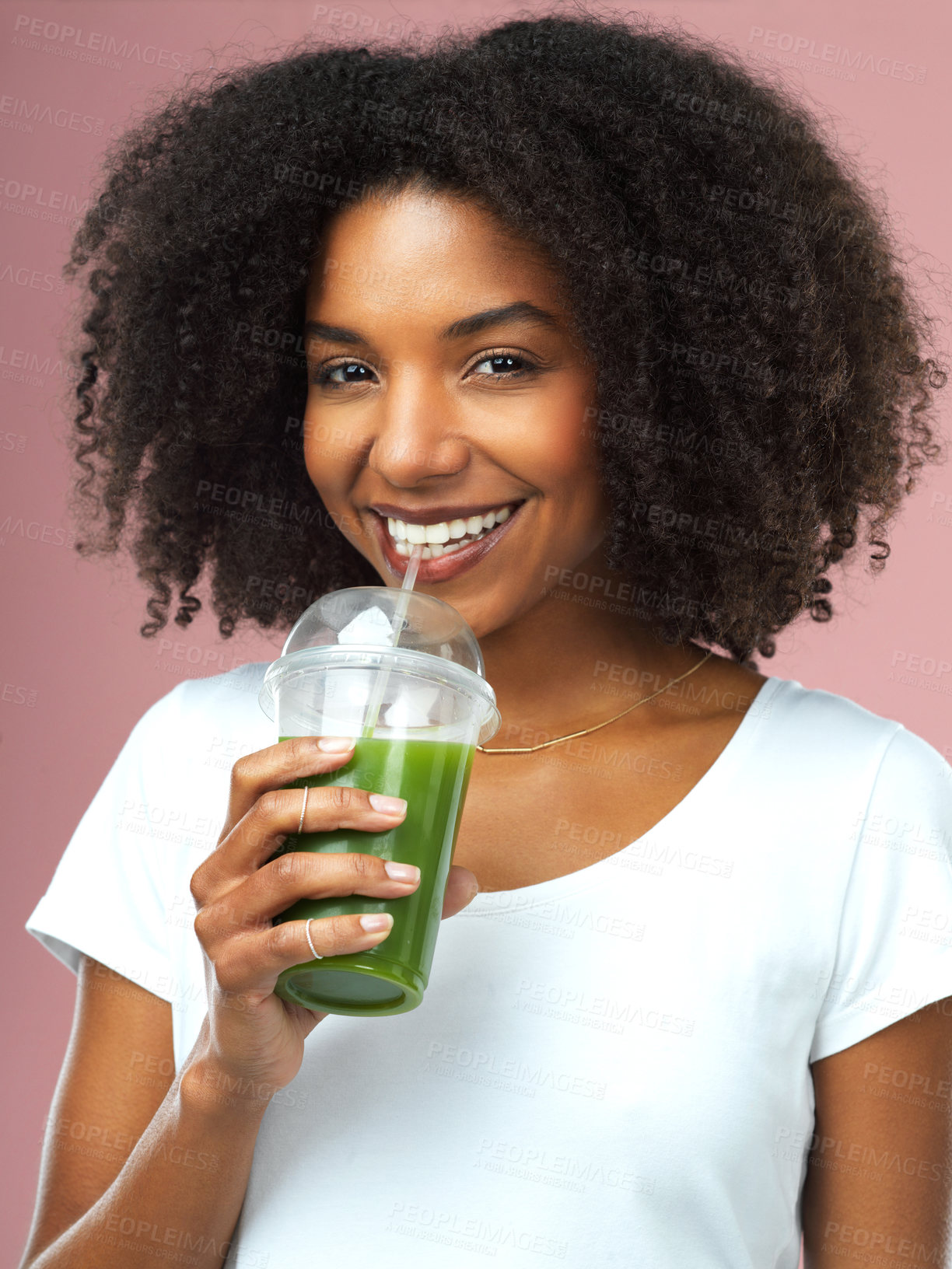 Buy stock photo Studio shot of an attractive young woman drinking green juice against a pink background