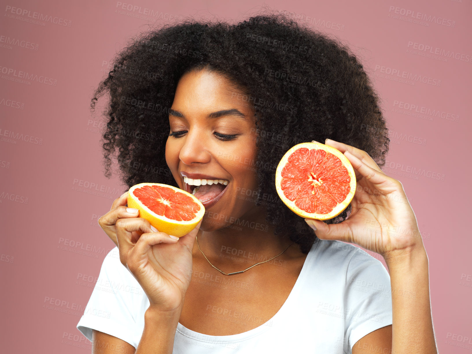 Buy stock photo Grapefruit, happy and black woman eat in studio isolated on a pink background. Natural, fruit and African female model eating food for vegan nutrition, vitamin c or healthy diet, hungry and wellness.