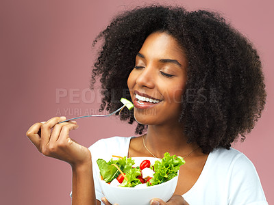Buy stock photo Studio shot of an attractive young woman eating salad against a pink background