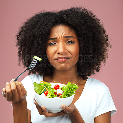 Buy stock photo Health, salad and portrait of black woman in studio eating vegetables for nutrition or vegan diet. Girl, pink background and unhappy for food, detox and wellness benefits for weight loss and dislike