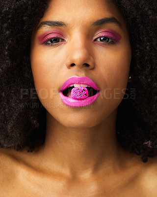 Buy stock photo Studio shot of an attractive young woman biting a piece of candy