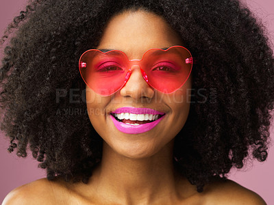 Buy stock photo Studio shot of an attractive young woman wearing heart shaped sunglasses against a pink background