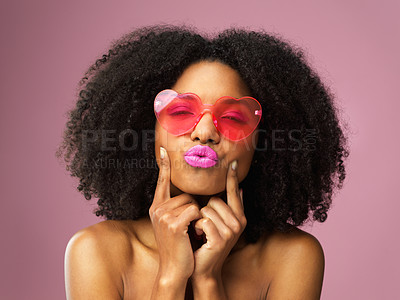 Buy stock photo Studio shot of an attractive young woman wearing heart shaped sunglasses and pouting against a pink background