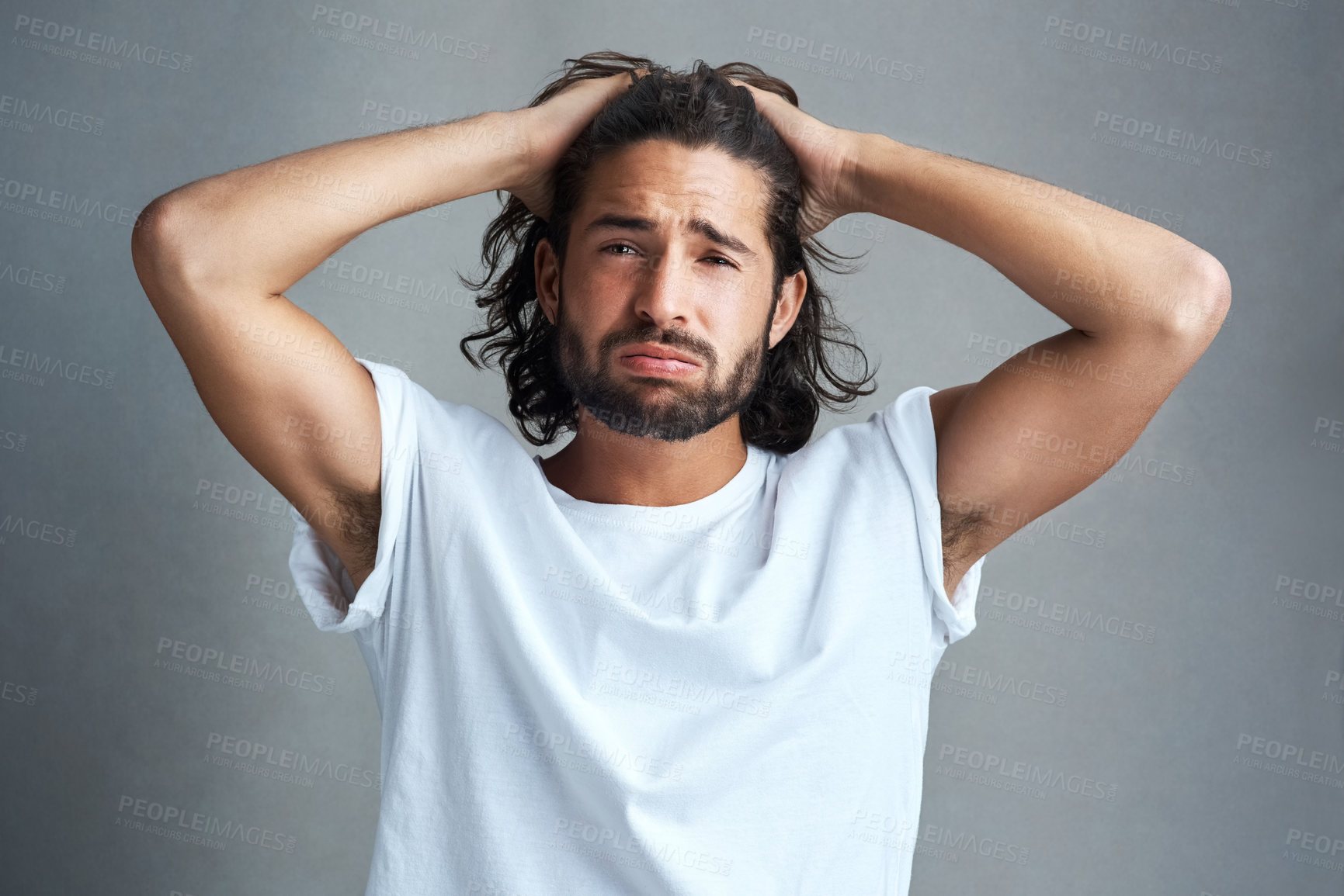 Buy stock photo Studio shot of a young man looking frustrated against a grey background
