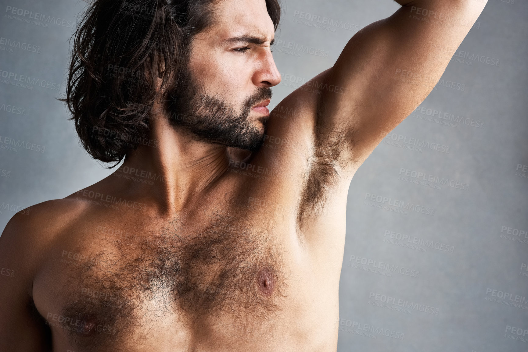 Buy stock photo Studio, sweat and man smelling underarm for grooming, skincare and poor hygiene in wellness treatment. Stink, skin and male model with strong body odor, bacteria and dirty armpit on grey background