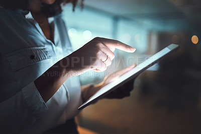 Buy stock photo Closeup shot of an unrecognizable businesswoman using a digital tablet in an office at night