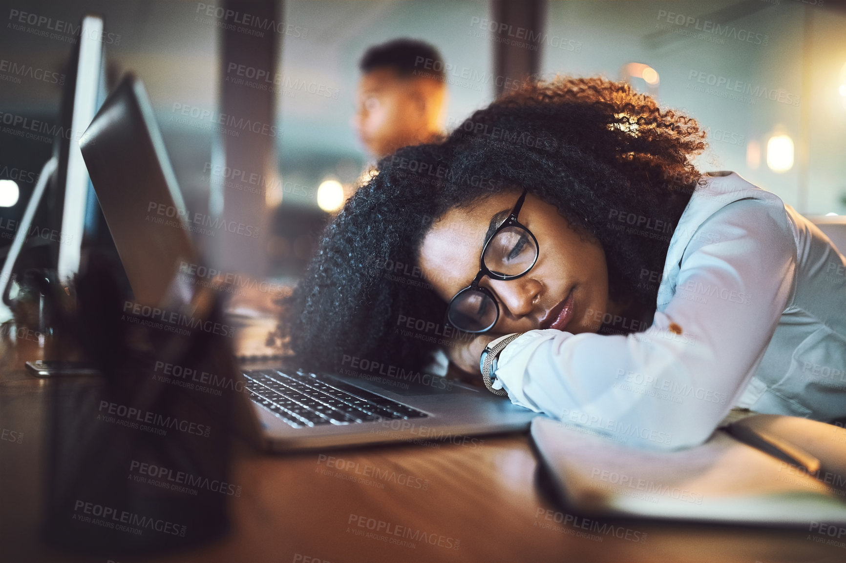 Buy stock photo Shot of a young businesswoman sleeping on her desk in an office at night