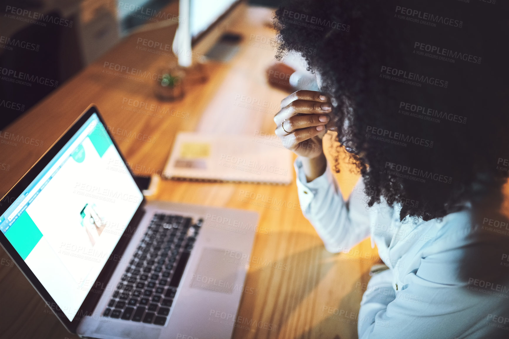Buy stock photo Shot of a young businesswoman rubbing her eyes while working on a laptop in an office at night