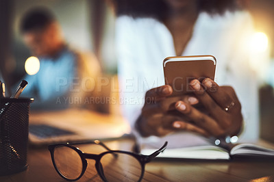 Buy stock photo Closeup shot of an unrecognizable businesswoman using a cellphone in an office at night