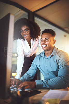 Buy stock photo Shot of two businesspeople working together on a computer in an office at night