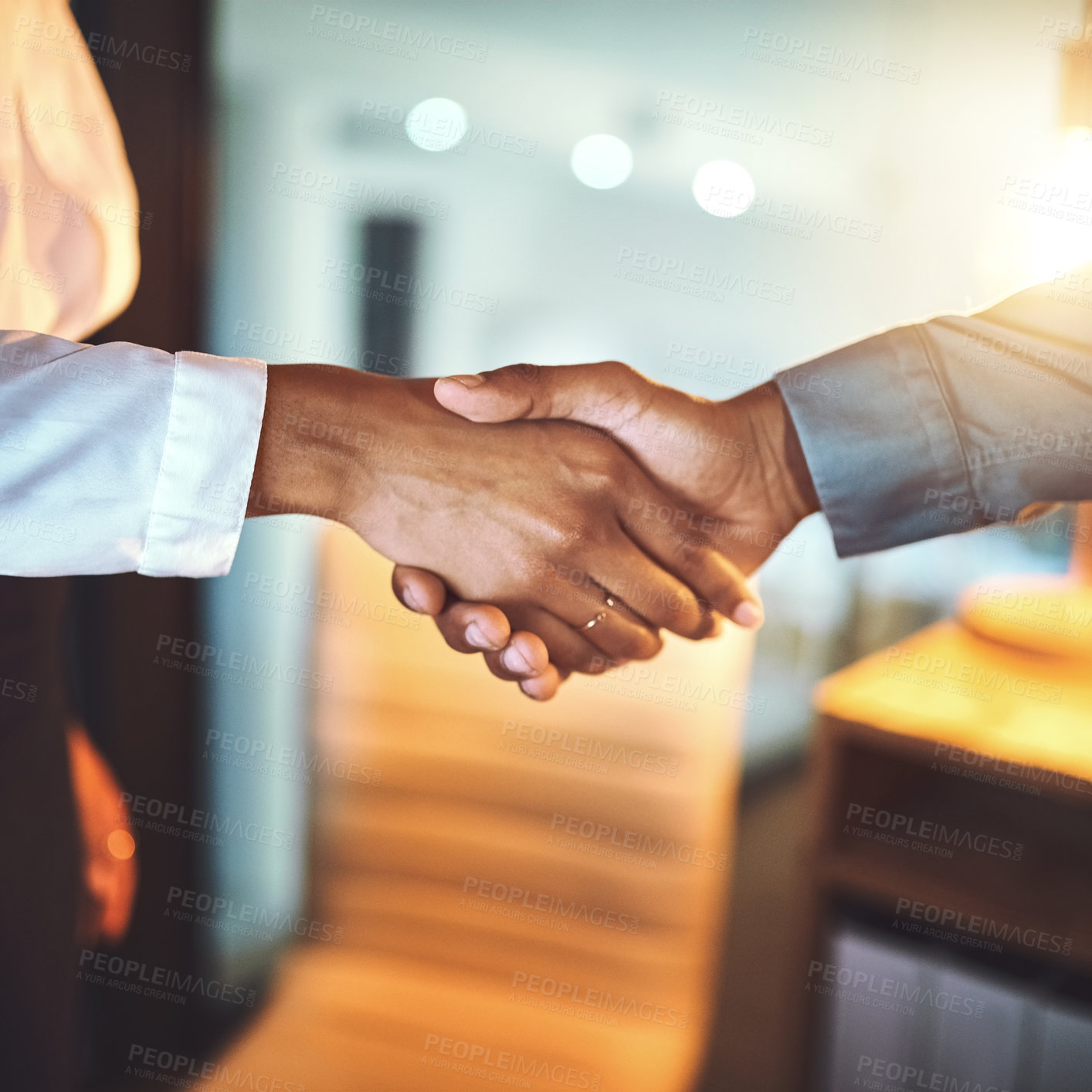 Buy stock photo Closeup shot of two unrecognizable businesspeople shaking hands in an office at night