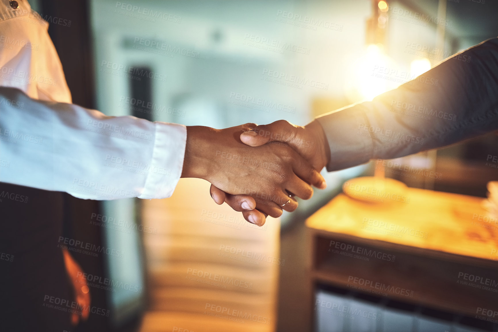 Buy stock photo Closeup shot of two unrecognizable businesspeople shaking hands in an office at night