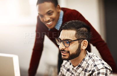 Buy stock photo Shot of two university students working together on a computer in the library on campus