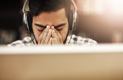 Buy stock photo Computer, headphones and Indian man in library with stress, headache and education at university. Anxiety, study and tired college student on campus with online course, class or webinar in earphones