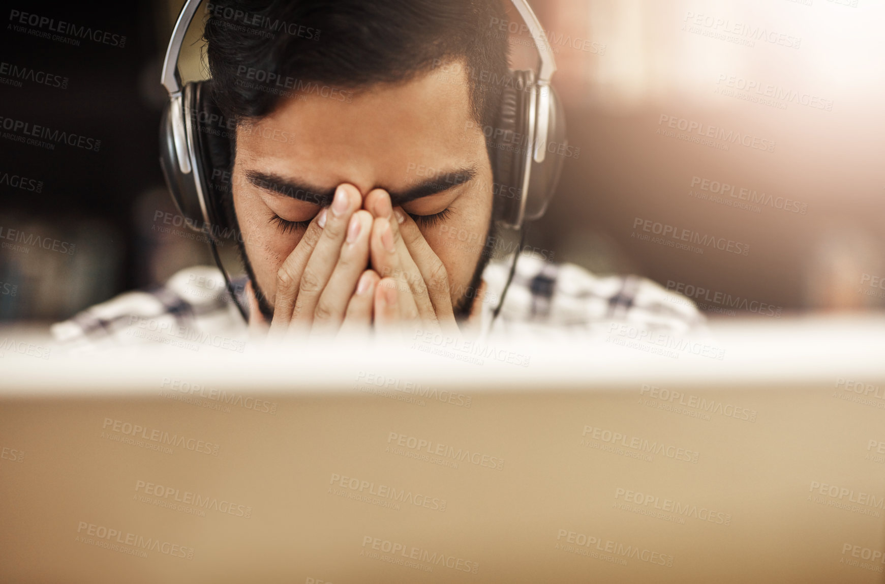 Buy stock photo Shot of a university student looking stressed out while working on a computer in the library on campus