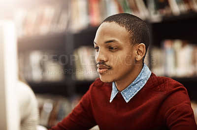 Buy stock photo Shot of a university student working on a computer in the library on campus
