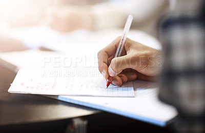 Buy stock photo Closeup shot of a university student writing notes in his book
