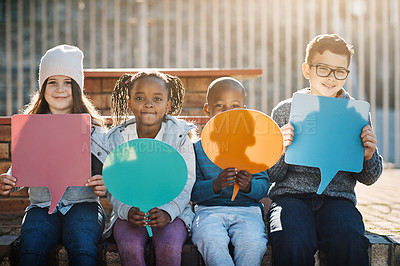Buy stock photo Cropped portrait of a group of elementary school kids holding up speech bubbles outside