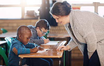 Buy stock photo Cropped shot of an elementary school teacher helping her students in the classroom