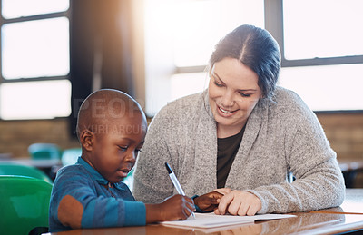 Buy stock photo Cropped shot of an elementary school boy and his teacher doing school work together in the classroom