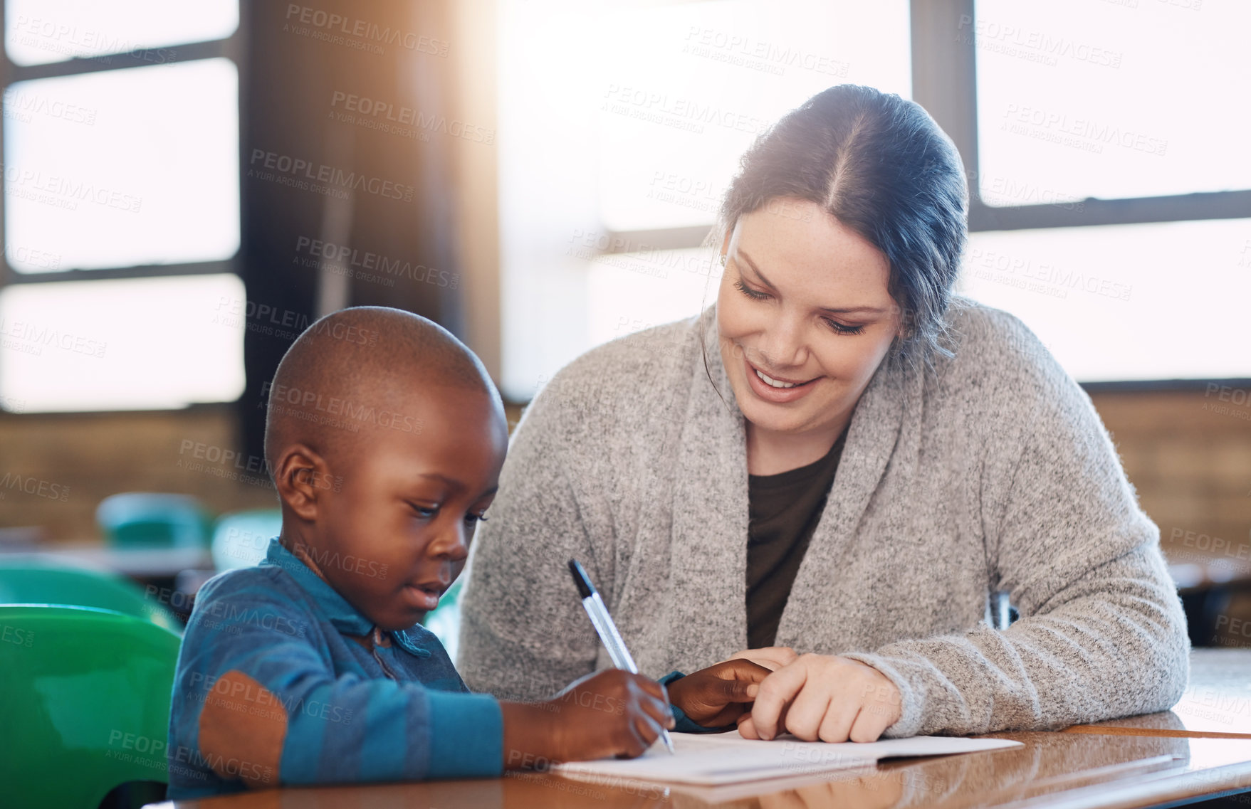 Buy stock photo Cropped shot of an elementary school boy and his teacher doing school work together in the classroom