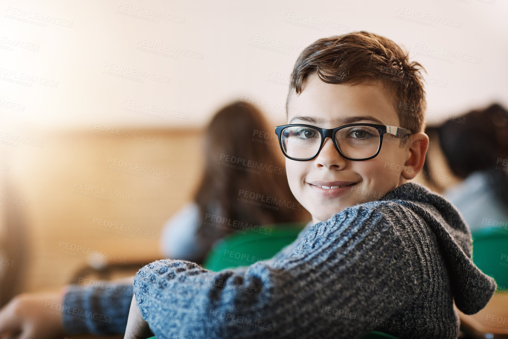 Buy stock photo Rearview portrait of an elementary school boy sitting in the classroom