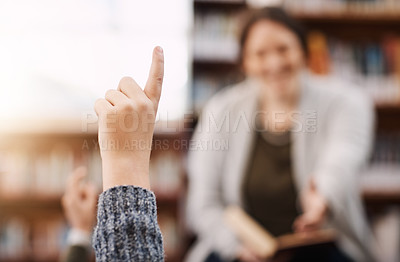 Buy stock photo Cropped shot of an elementary school boy sitting with his hand raised in the library