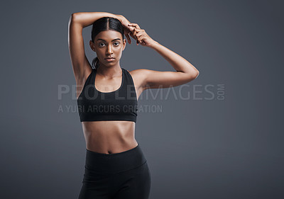 Buy stock photo Portrait, space and stretching with an athlete woman in studio on a gray background for fitness or health. Exercise, workout or warm up and an attractive young female model training with mockup 