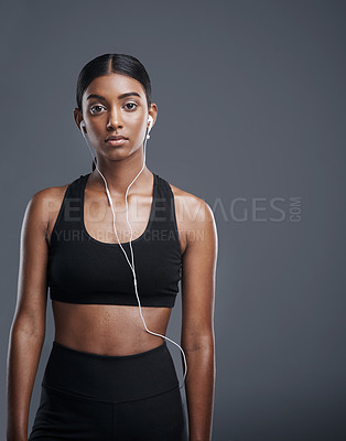 Buy stock photo Fitness, headphones and portrait of woman in studio for workout, exercise and listening to music. Sport, person and athlete with serious face for cardio, podcast and training pride on gray background