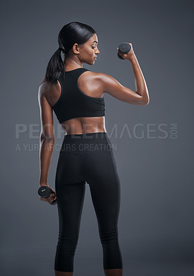 Buy stock photo Indian woman, dumbbells and exercise for fitness in studio on grey background for health, muscles and sportswear. Profile, workout and committed for wellbeing with weights for training and wellness