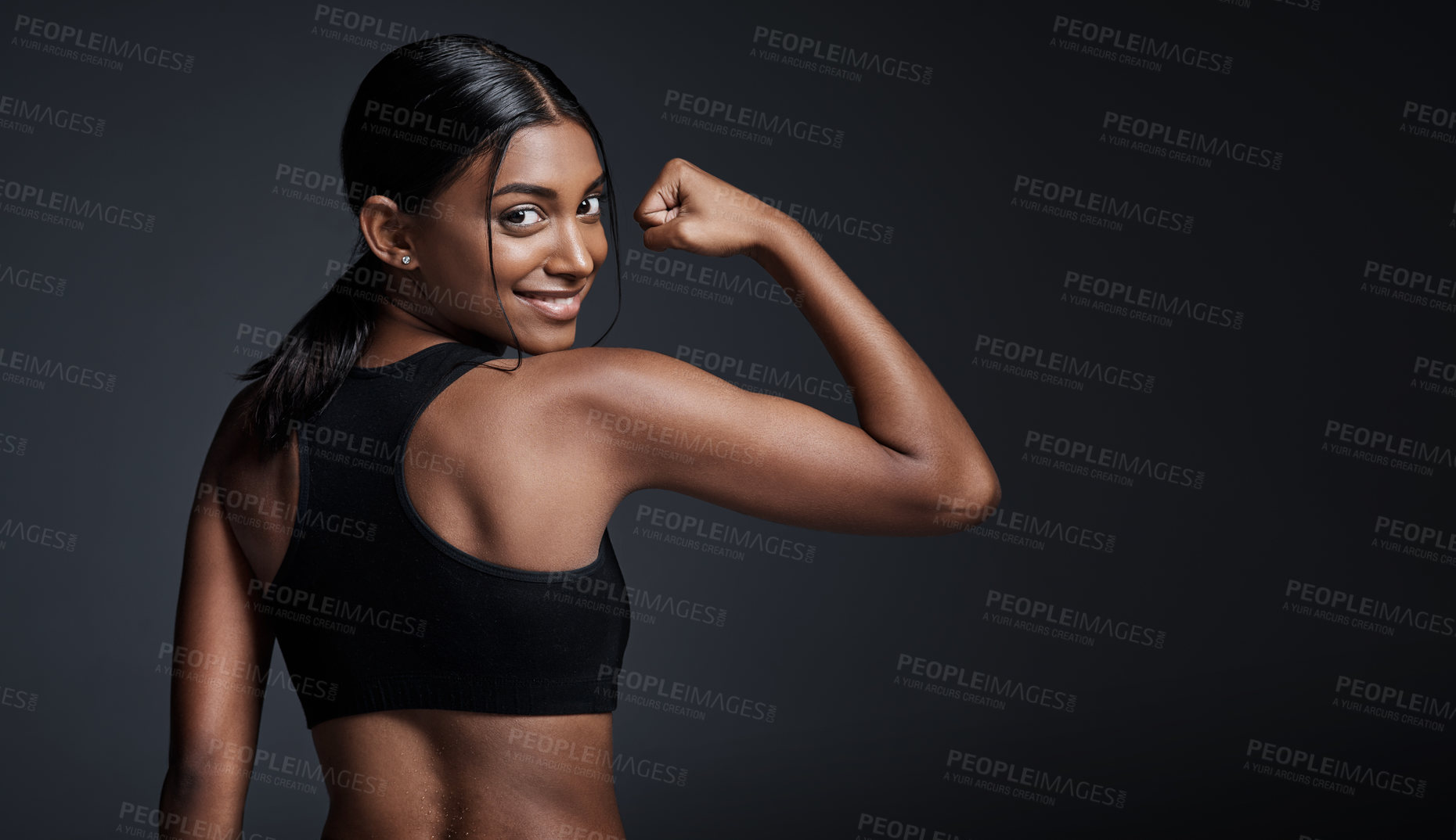 Buy stock photo Portrait, smile and woman flexing back in studio isolated on a black background mockup. Strong flex, happy and Indian female athlete with bicep, arm strength or bodybuilder muscle, fitness or workout