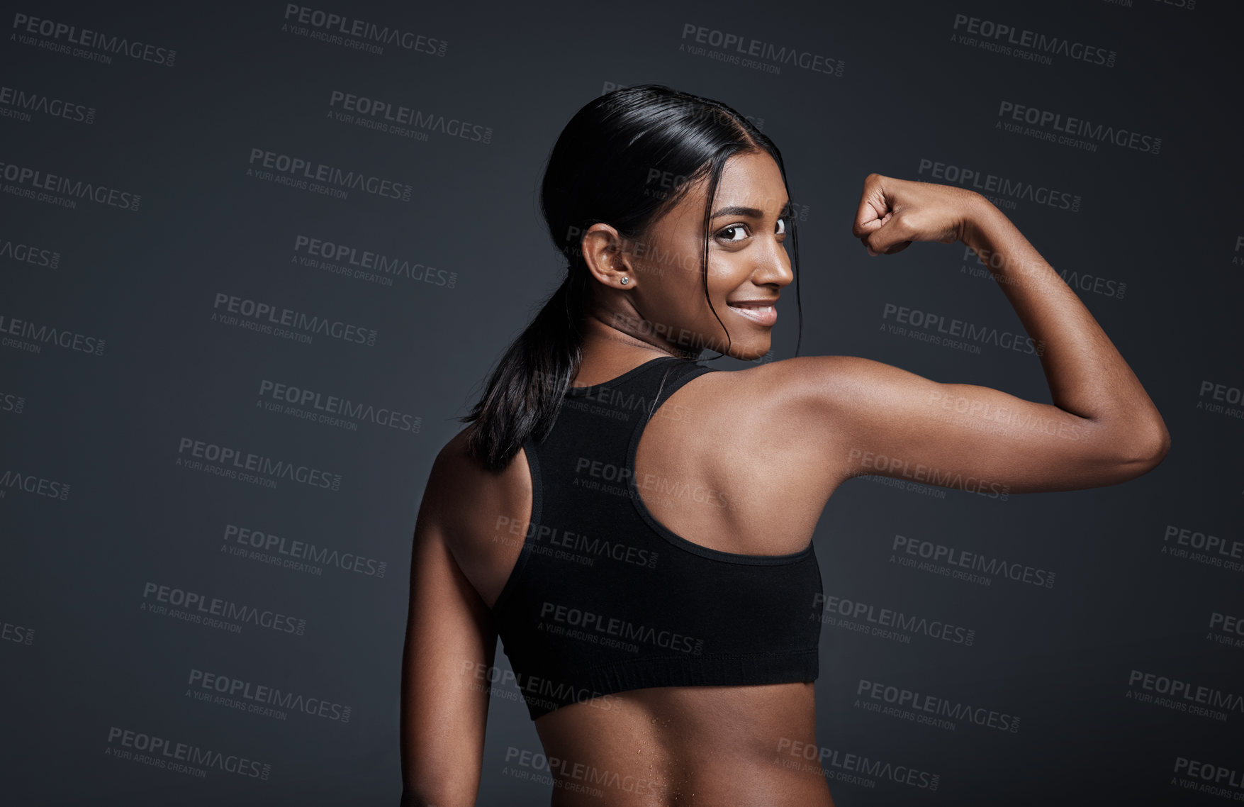 Buy stock photo Portrait, happy and woman flexing back in studio isolated on a black background mockup. Strong flex, smile and Indian female athlete with bicep, arm strength or bodybuilder muscle, fitness or workout