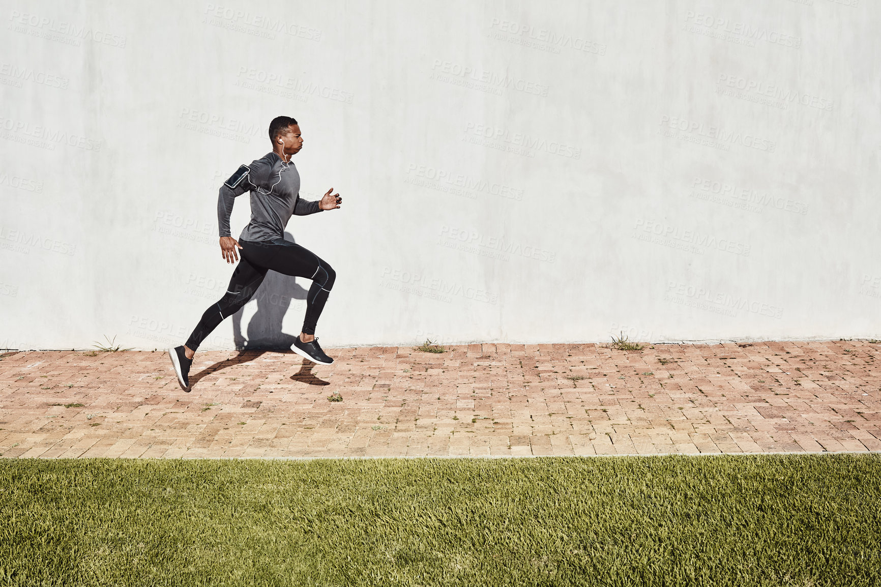 Buy stock photo Full length shot of a handsome and athletic young man running on a path through the park