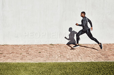 Buy stock photo Full length shot of a handsome and athletic young man running on a path through the park