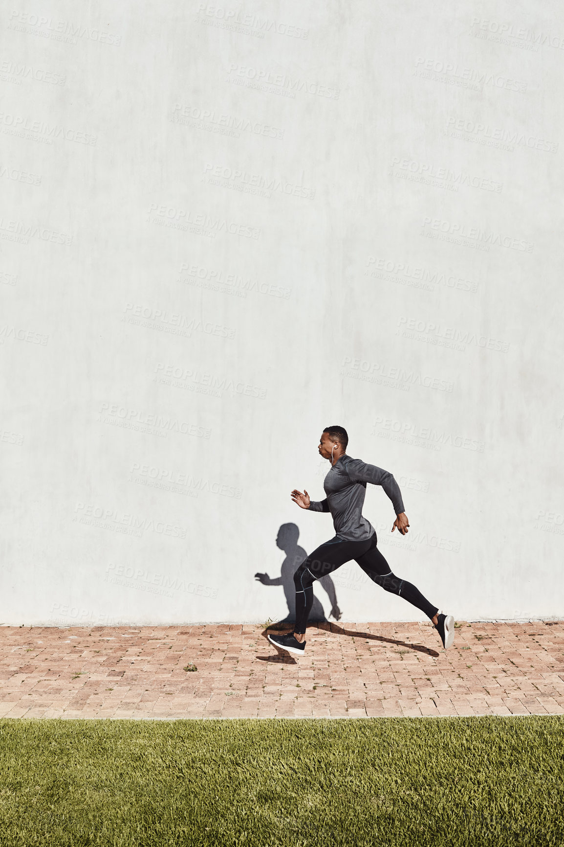 Buy stock photo Full length shot of a handsome and athletic young man running on a path through the park