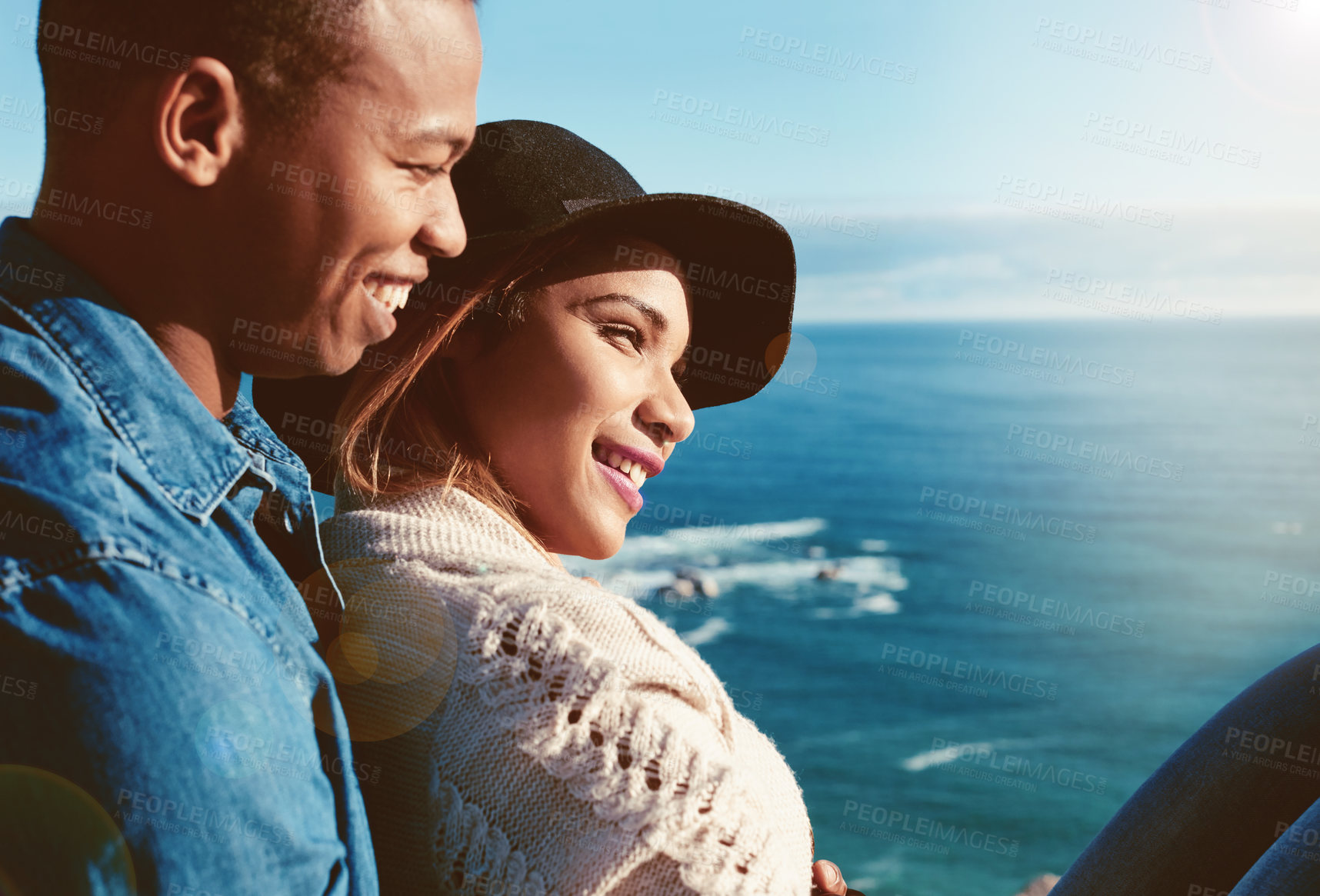 Buy stock photo Shot of a happy young couple enjoying the ocean view on a romantic day outdoors