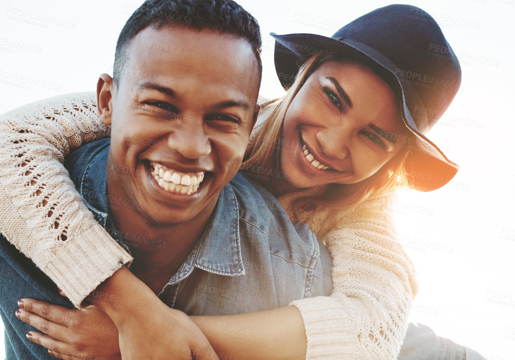 Buy stock photo Shot of a happy young couple enjoying a piggyback ride outdoors