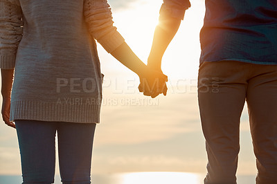 Buy stock photo Rearview shot of a young couple holding hands outdoors