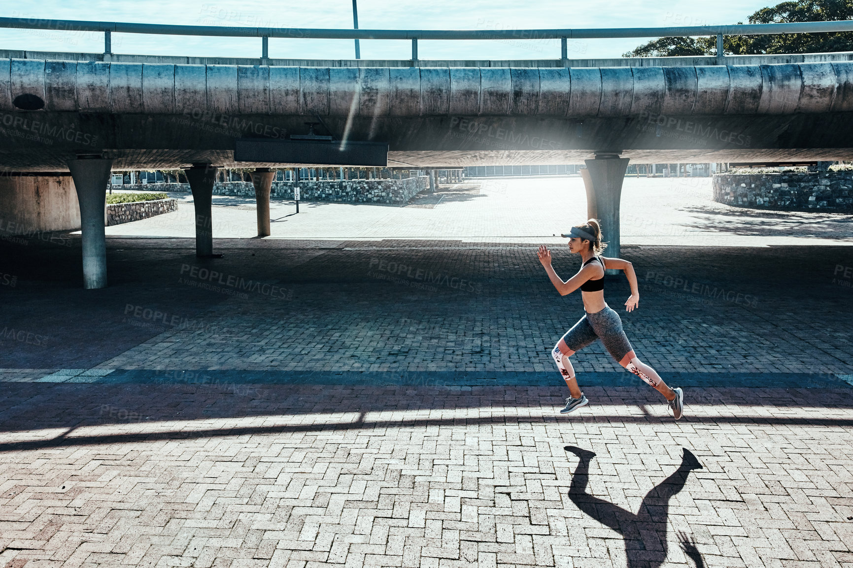 Buy stock photo Full length shot of an attractive and athletic young woman running through the city