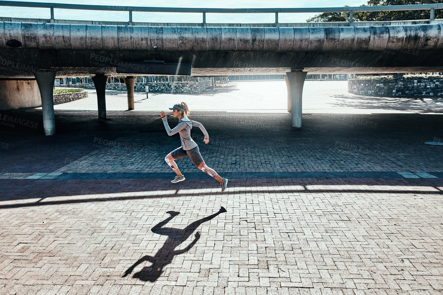 Buy stock photo Full length shot of an attractive and athletic young woman running through the city