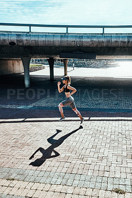 Buy stock photo Full length shot of an attractive and athletic young woman running through the city